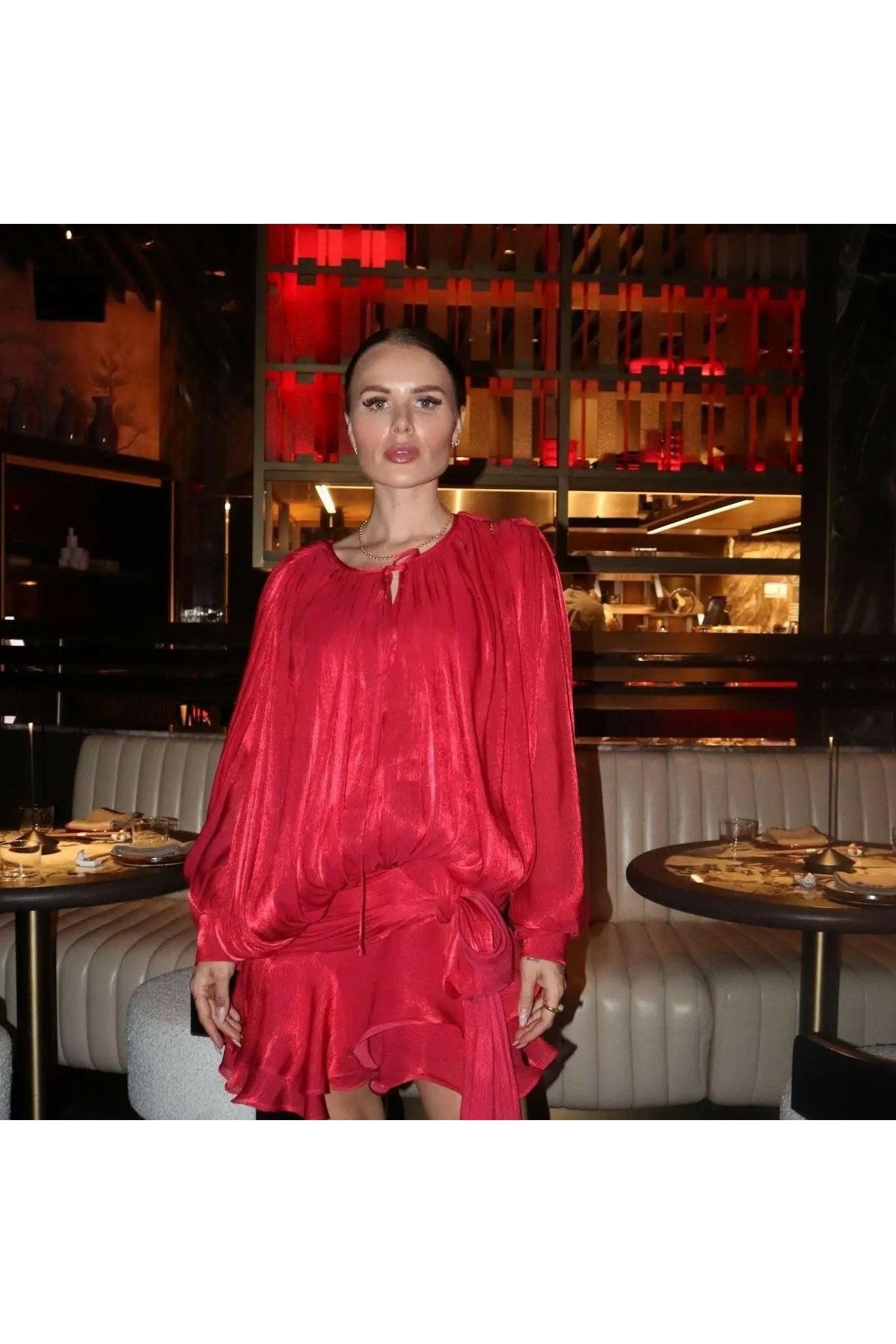 Frau im roten Éloïse Plissee Kleid in eleganter Restaurant-Umgebung