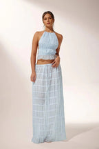 Miraee Paris light blue two-piece set with a pleated halter top and matching flowing maxi skirt in chiffon fabric.