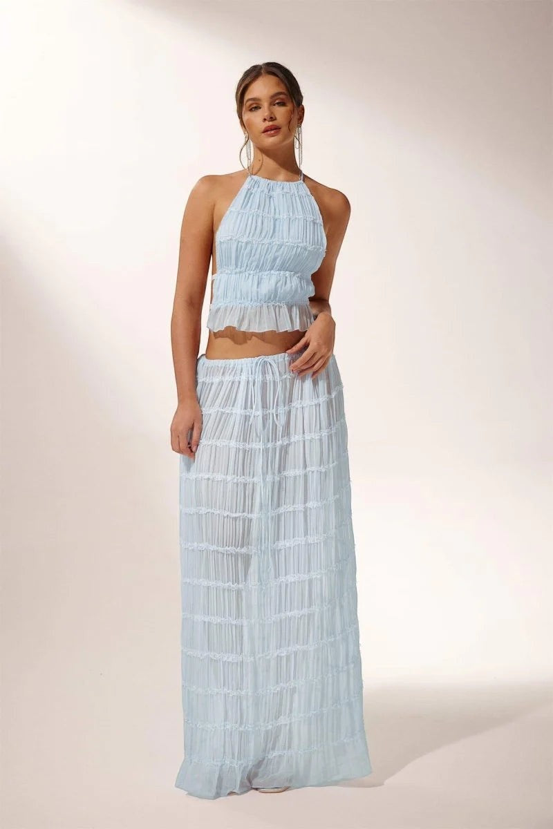 Miraee Paris light blue two-piece set with a pleated halter top and matching flowing maxi skirt in chiffon fabric.